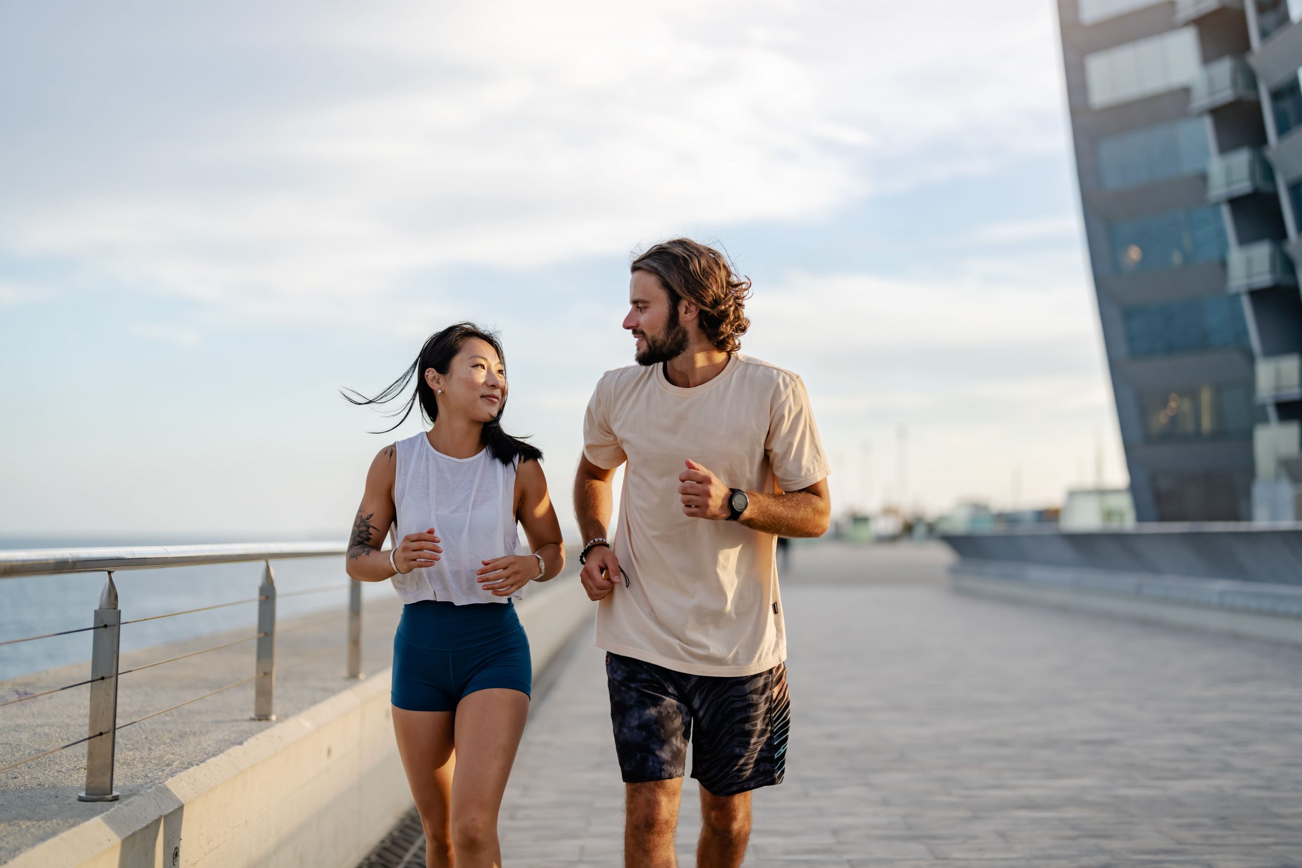 Casal correndo com roupas fitness versáteis em ambiente urbano